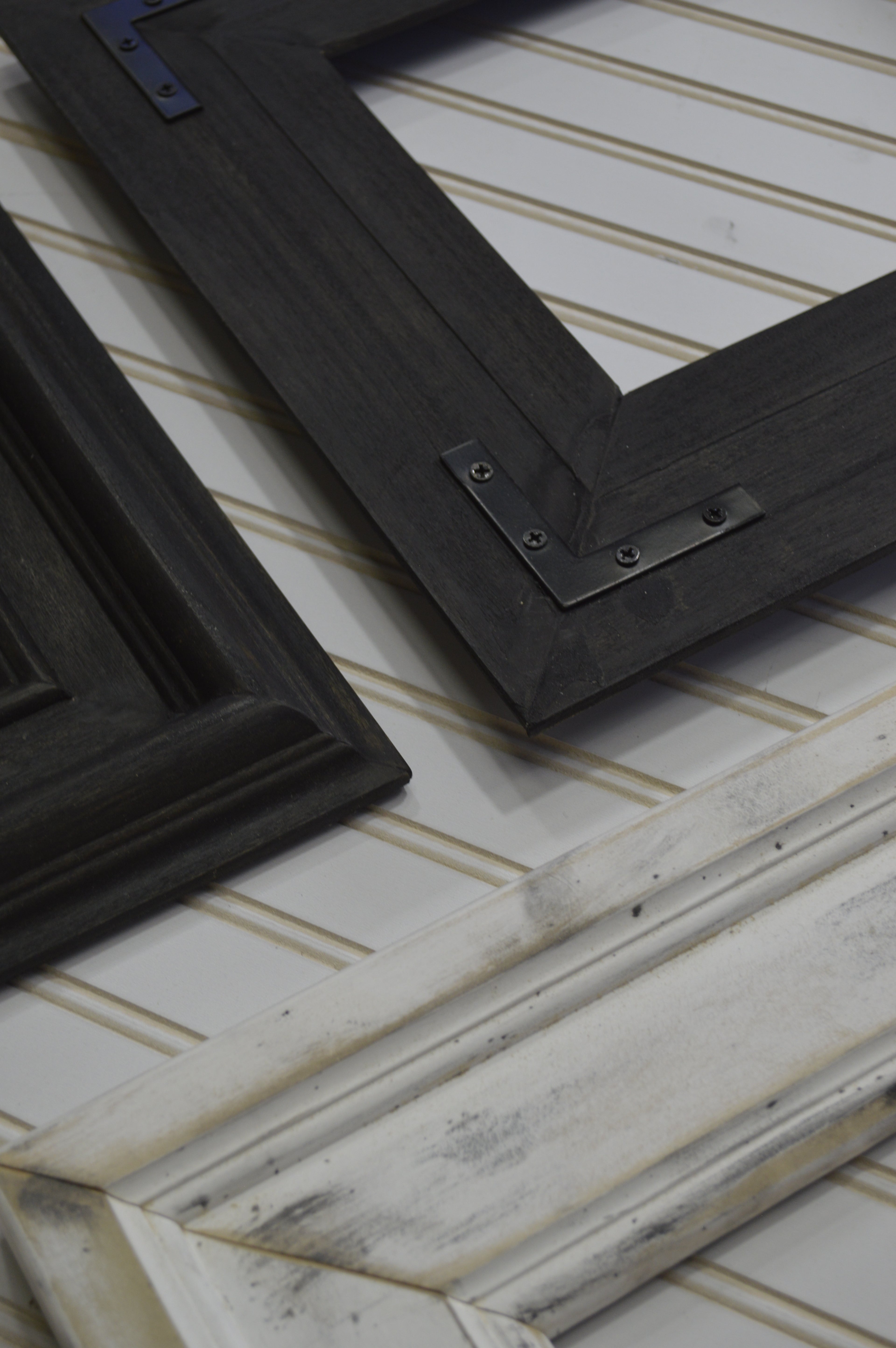 Two black picture frames on a textured white surface with gold accents